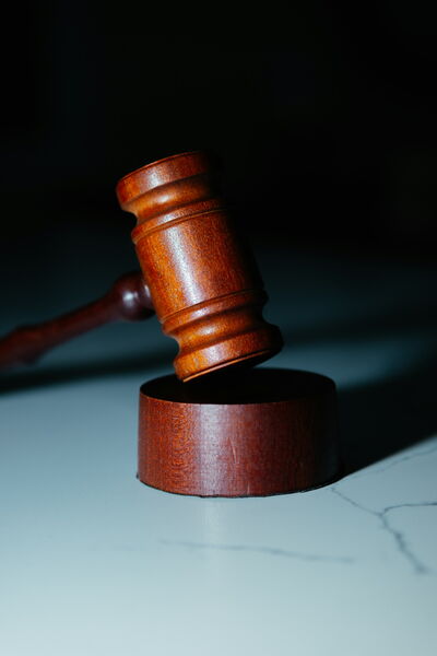 Ein Holzhammer liegt auf einem weißen Tisch, steht für rechtliche Vorschriften und juristische Themen.